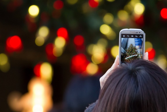Iluminasi di Ginza: seorang wanita memotret pohon Natal